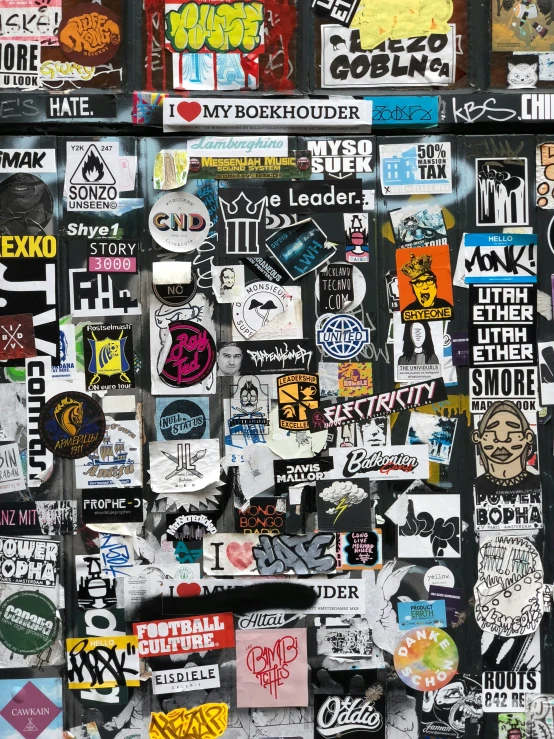 there are lots of stickers on this black wall