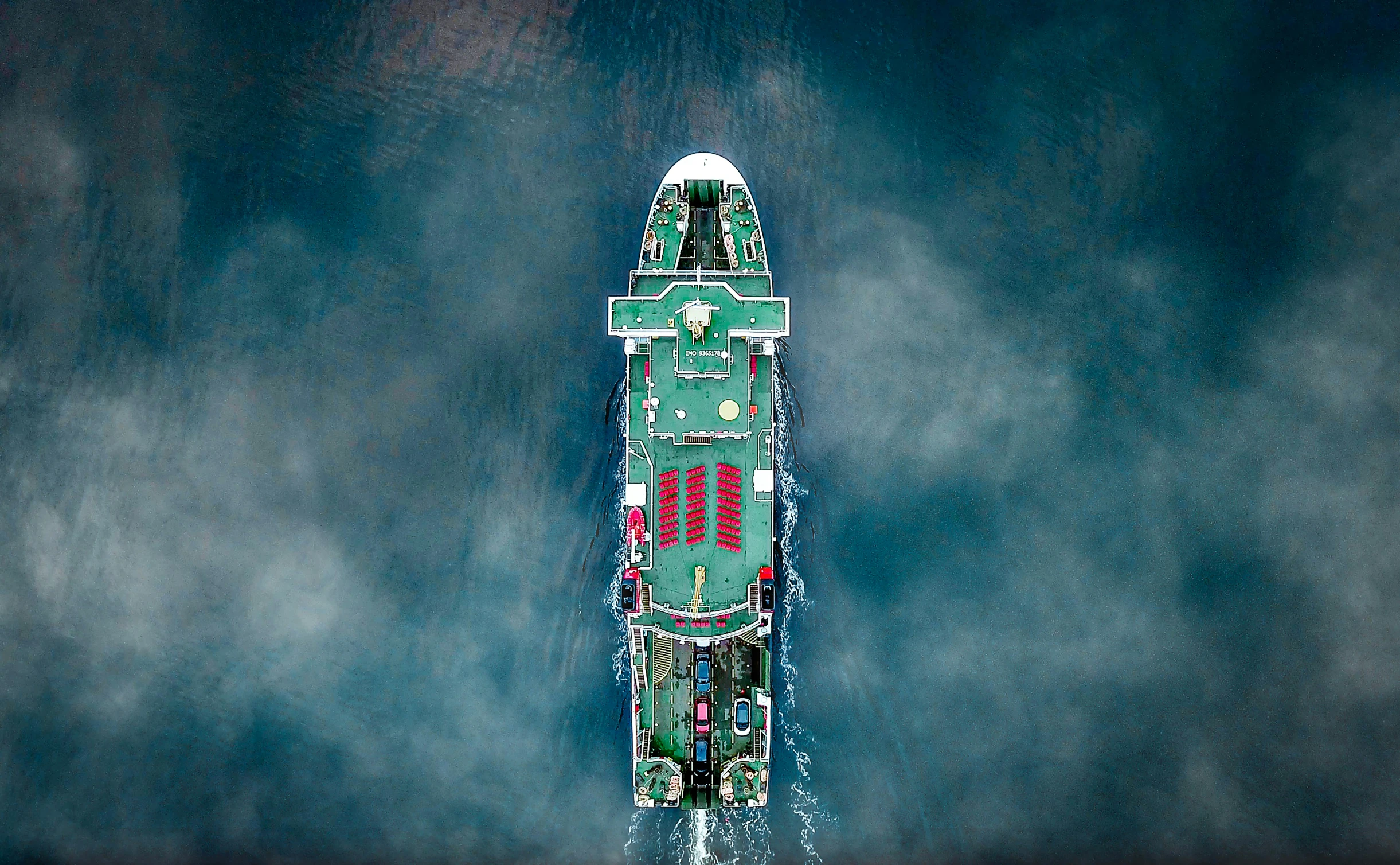 an aerial view of a green boat with four red windows