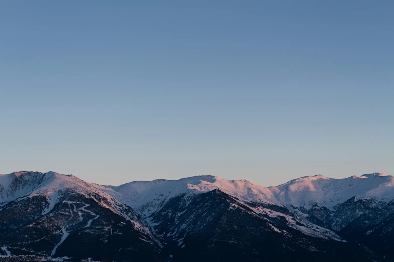 some snow covered mountains and one person in the distance