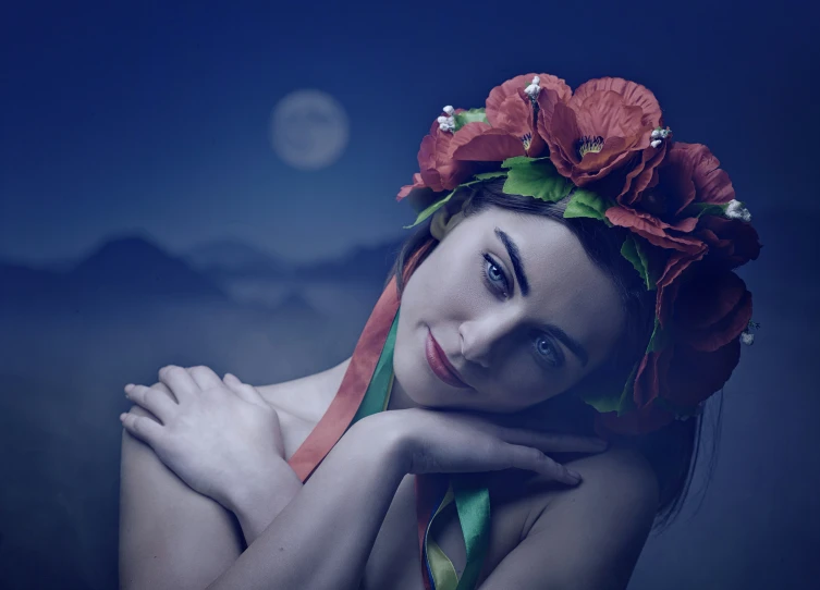 a young woman wearing a flowered headpiece with a blue background