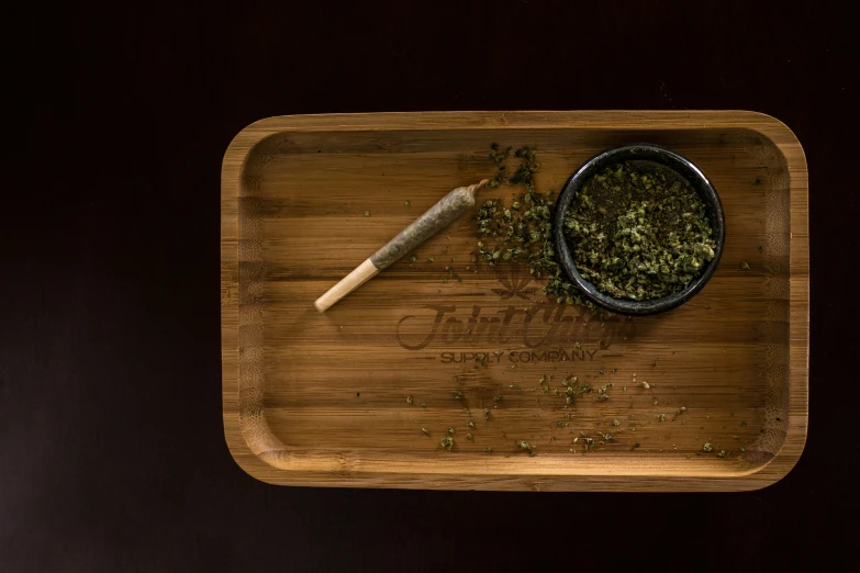 a wooden tray holding a bowl and a spoon