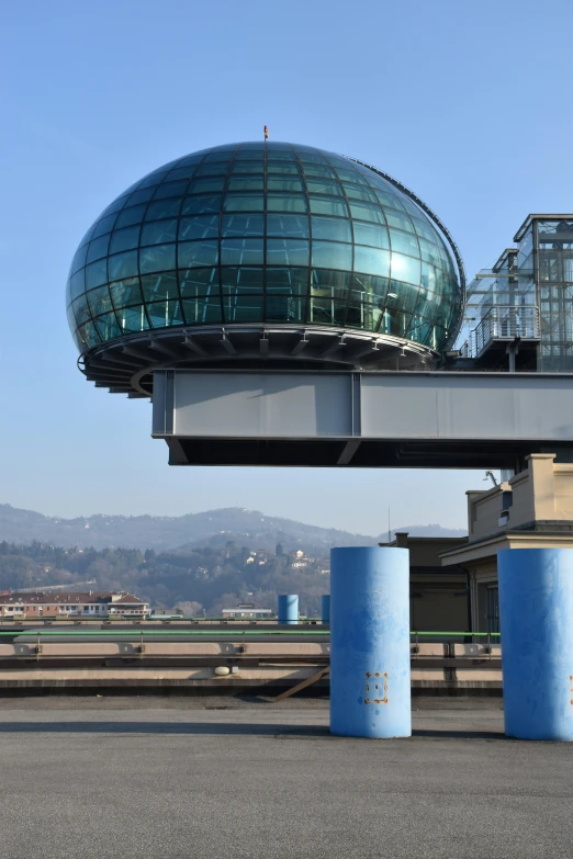 an overpass over a roadway with blue barrels near it