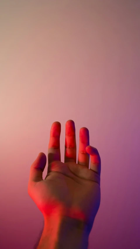the red light is shining from below of a hand