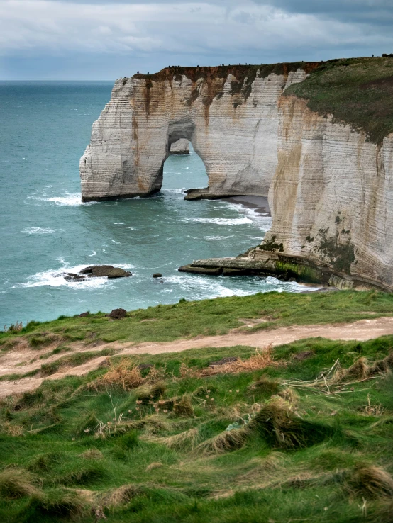 there is a rock arch that has a beach below