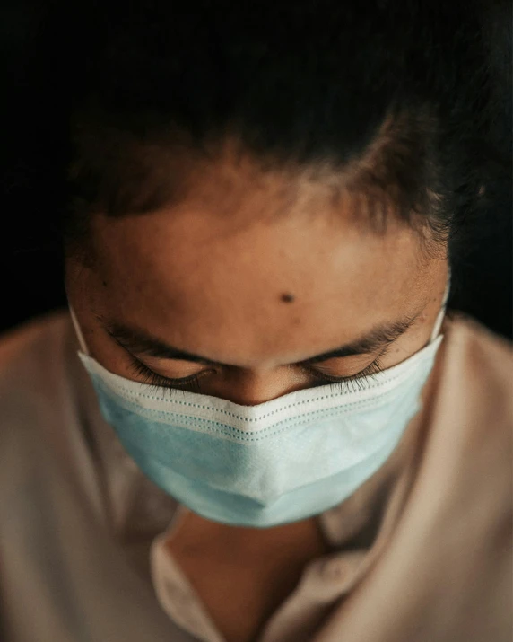 man wearing medical face mask on black background