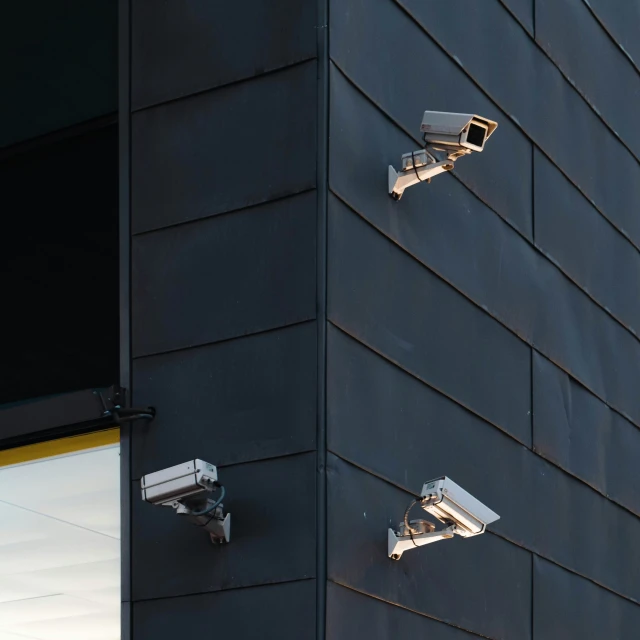 two security cameras mounted to the side of a building