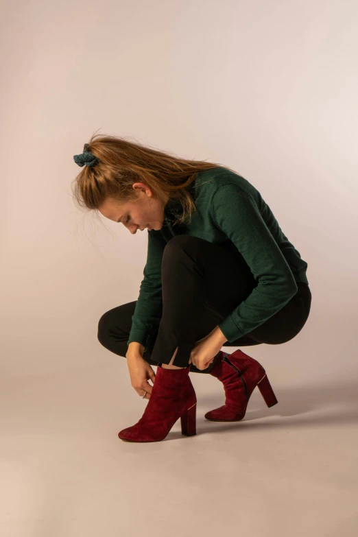 the young woman is sitting down with her boots on