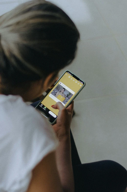 woman looking at a cell phone with her face in a square