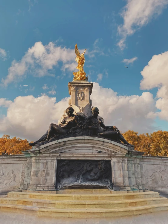 a statue with a golden statue is in the middle of a field