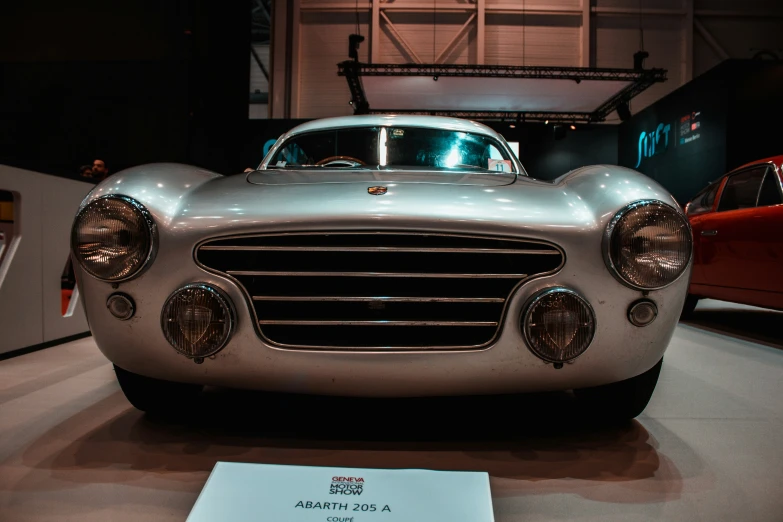 two vintage cars on display in a museum