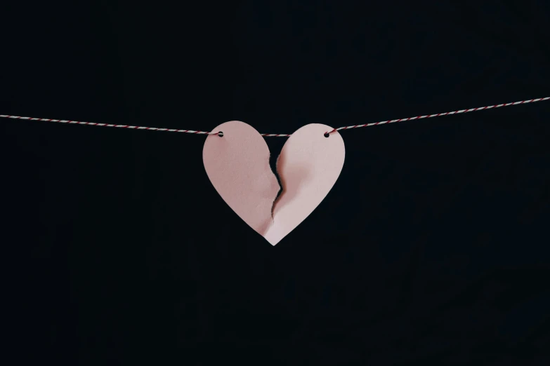a paper heart hanging on a line with no strings
