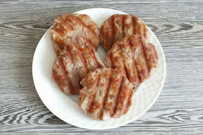 four meatballs are shown on a white plate