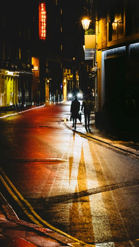 a person crossing a city street at night