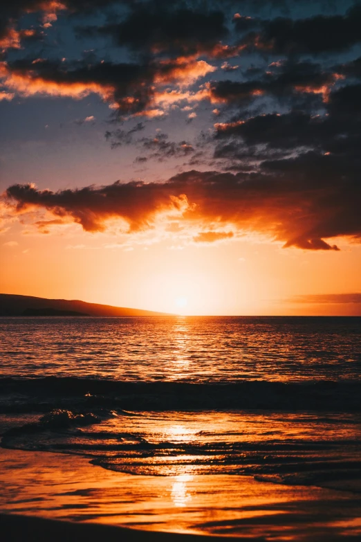 the sun rising over the horizon at the beach