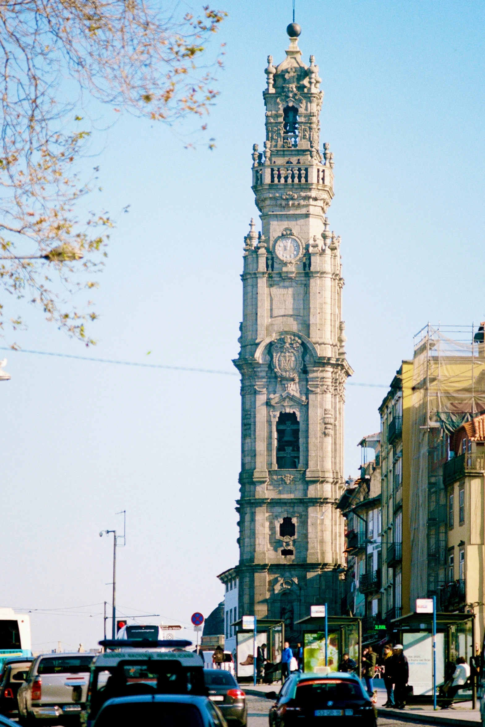 a clock tower rises above a busy city street