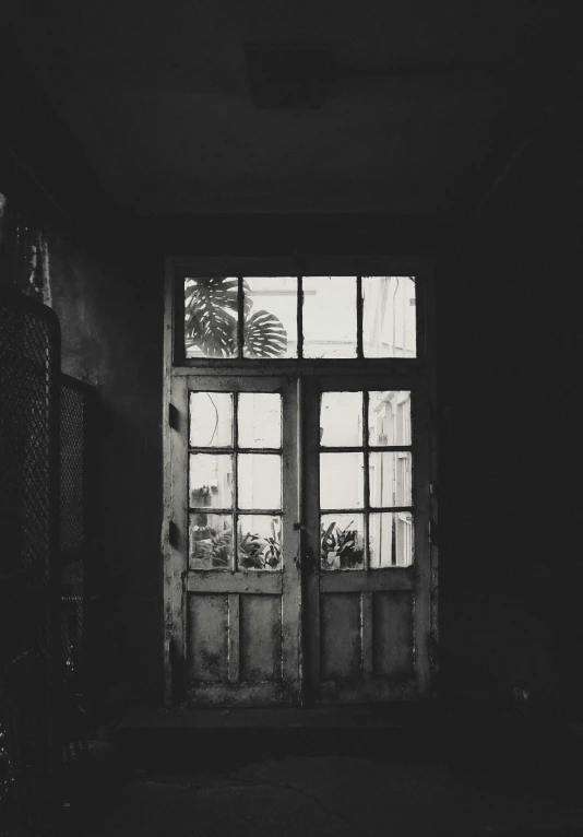 a dark room with a door and several windows