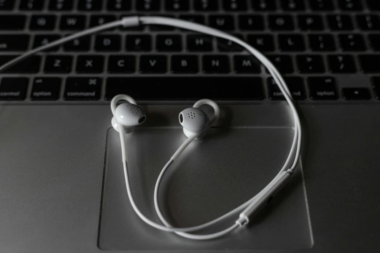 a pair of headphones sitting on a laptop