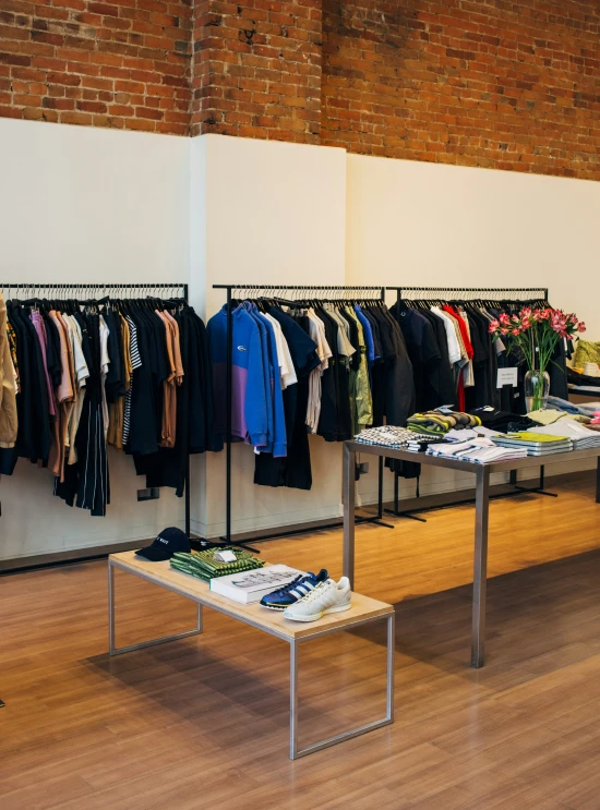 several racks of shirts are hung on tables