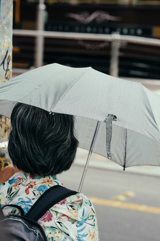 a person walking on the side walk with an umbrella