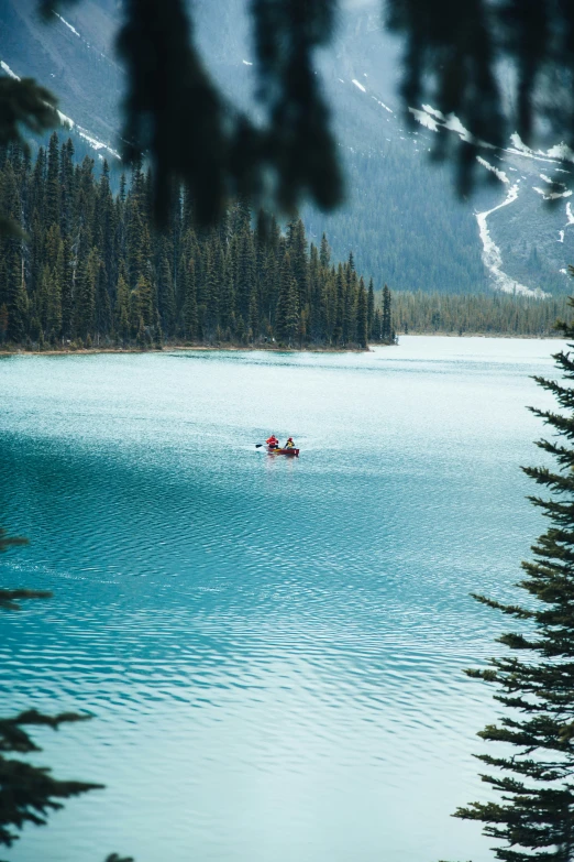 two people riding paddle boats in a mountain lake