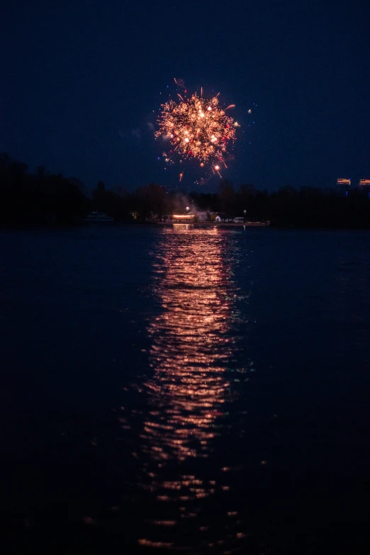 a beautiful s of some fireworks reflected in the water