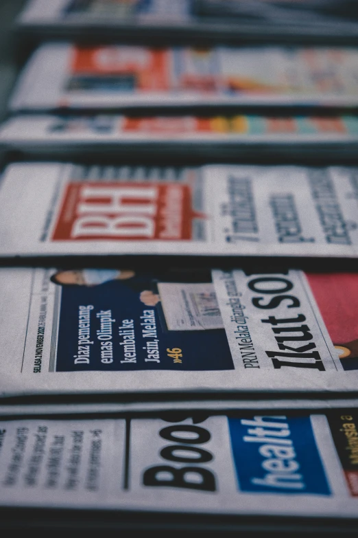 many newspapers lie on top of each other on the ground