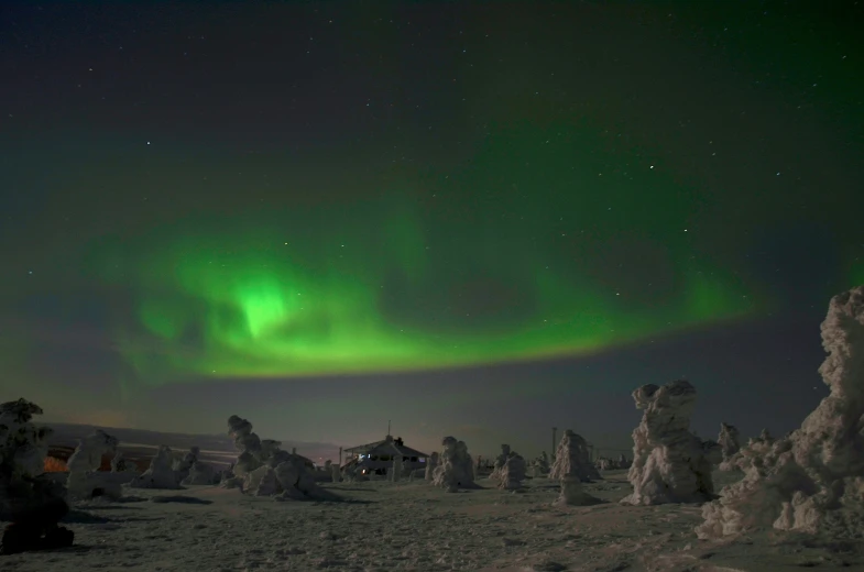 the green aurora is in the sky above a snowy landscape