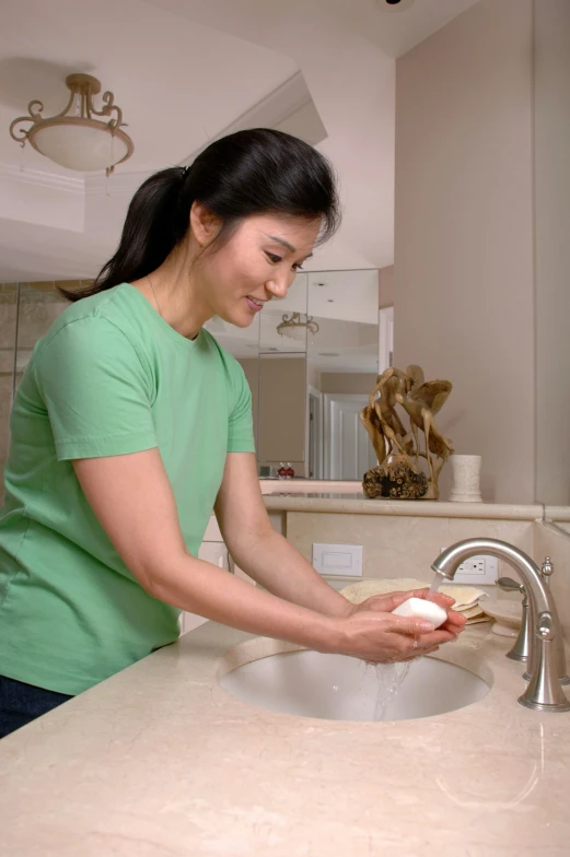 a woman holding a toothbrush in a bathroom sink