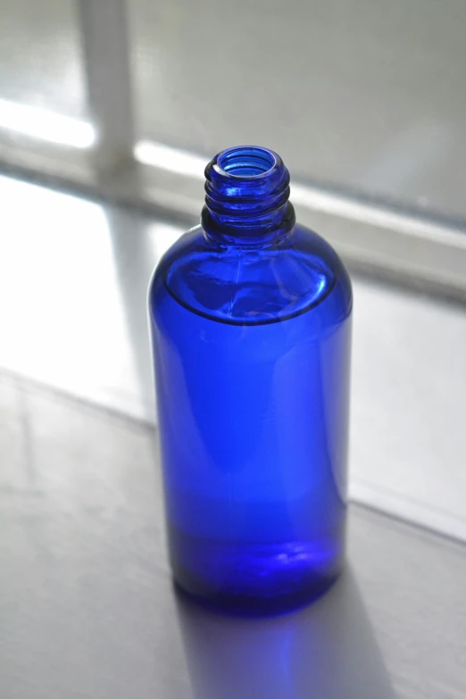 a blue glass bottle with a long neck and bottom