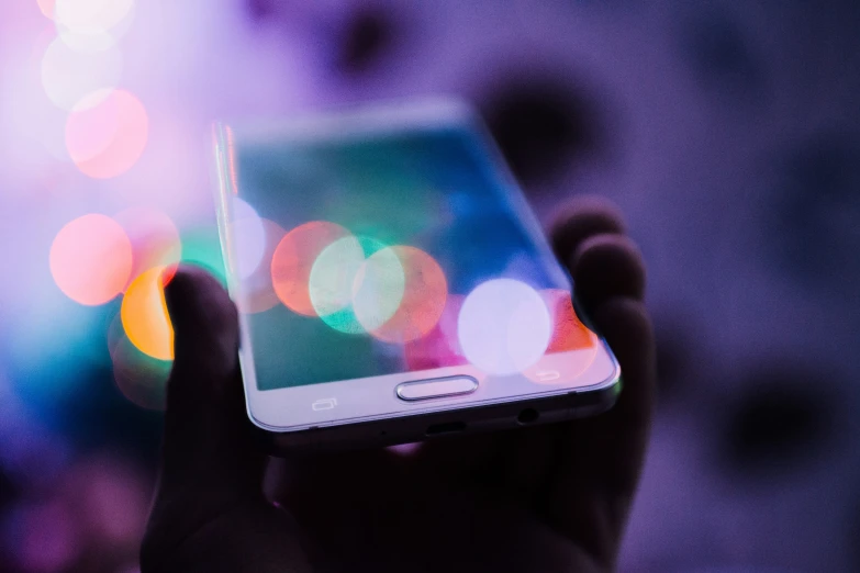 a person holding their cell phone in the dark