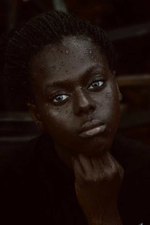 a woman with dark skin looks into the camera