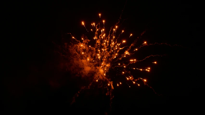 fireworks exploding in the dark sky with orange and white sparks