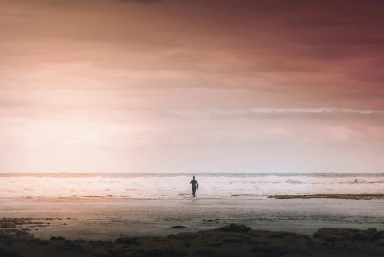 a person in the ocean near the shore under a cloudy sky