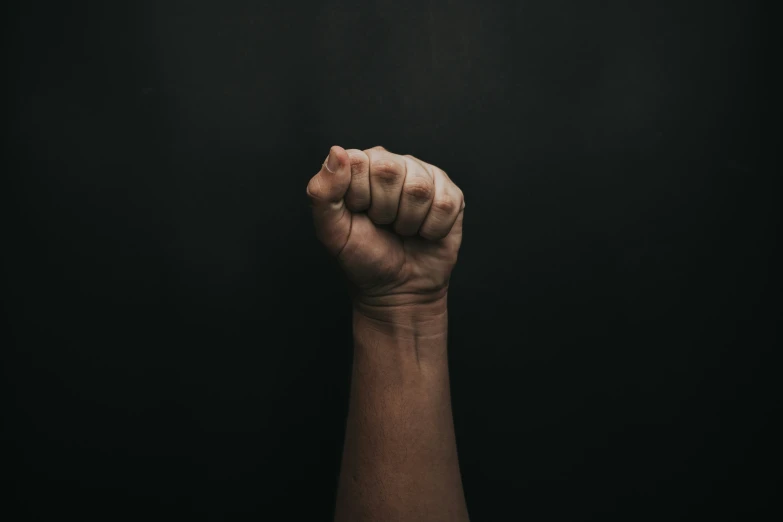 a person holding their fist up in the dark