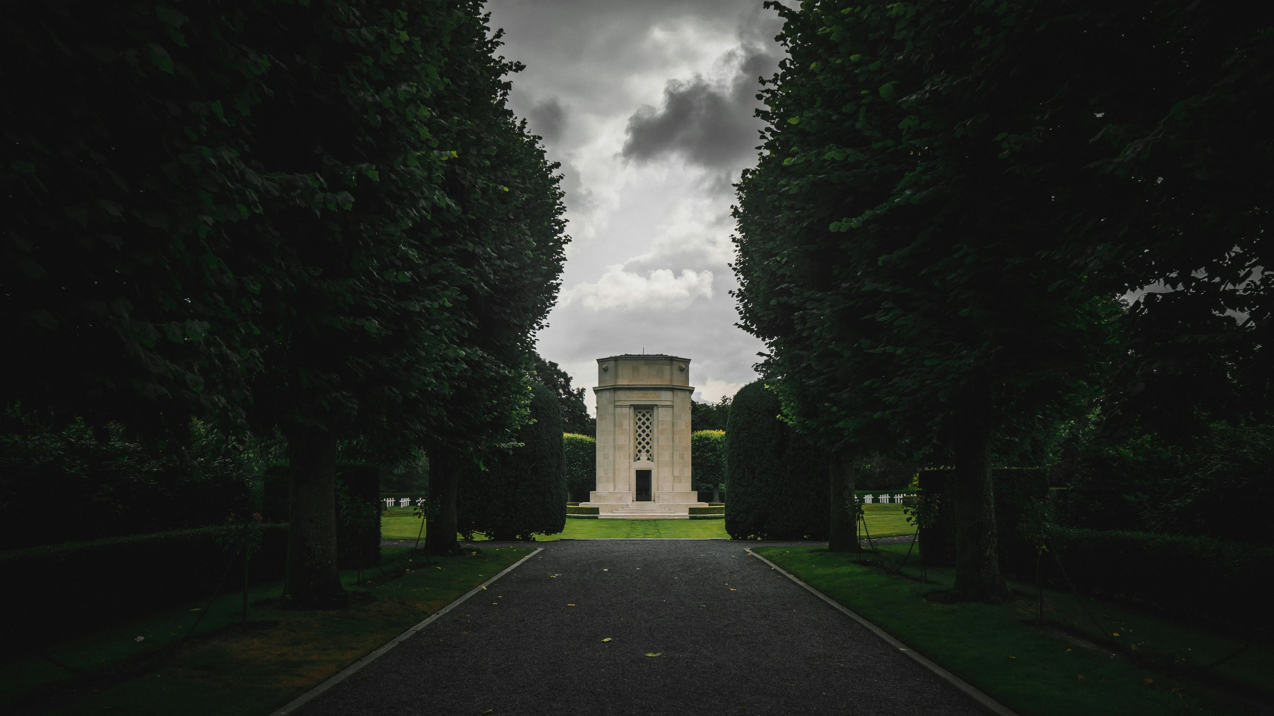 a tall statue is in between two trees