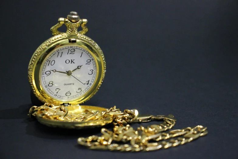 an old style golden pocket watch sitting on a table