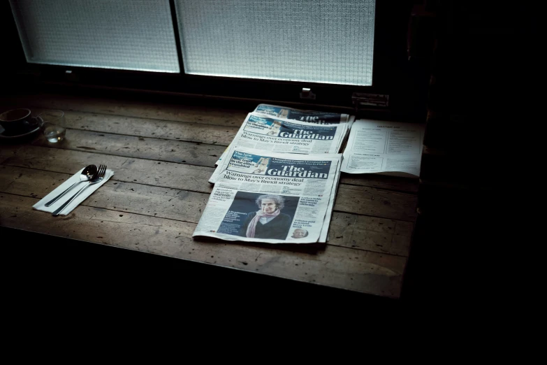 newspaper, knife and fork are resting on the table