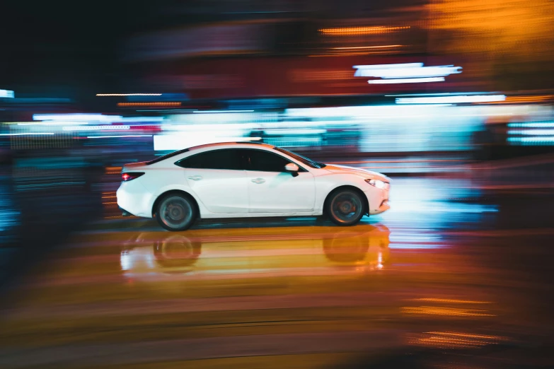 a white car with shiny paint driving on the street