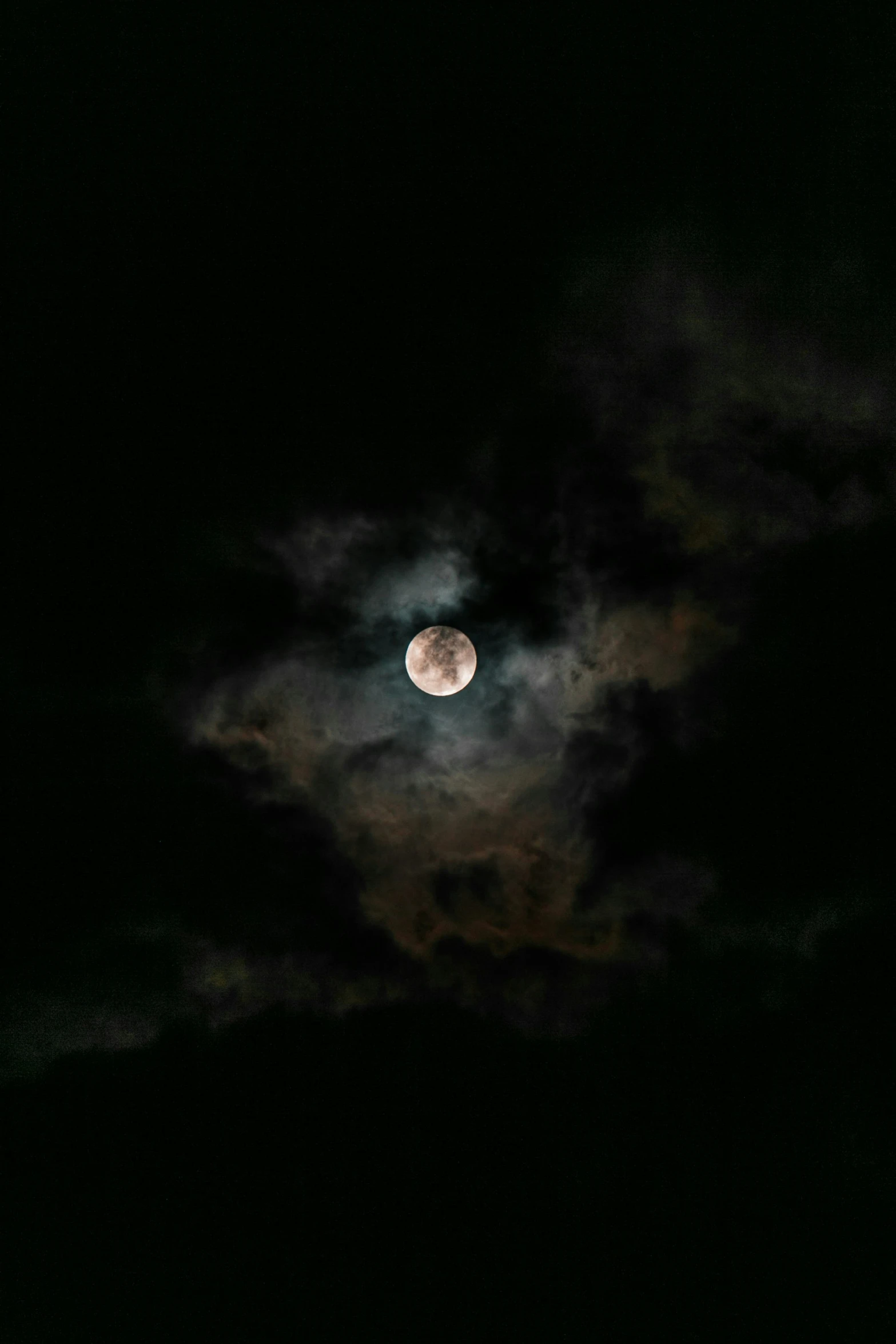 the full moon with clouds and some light reflecting off it