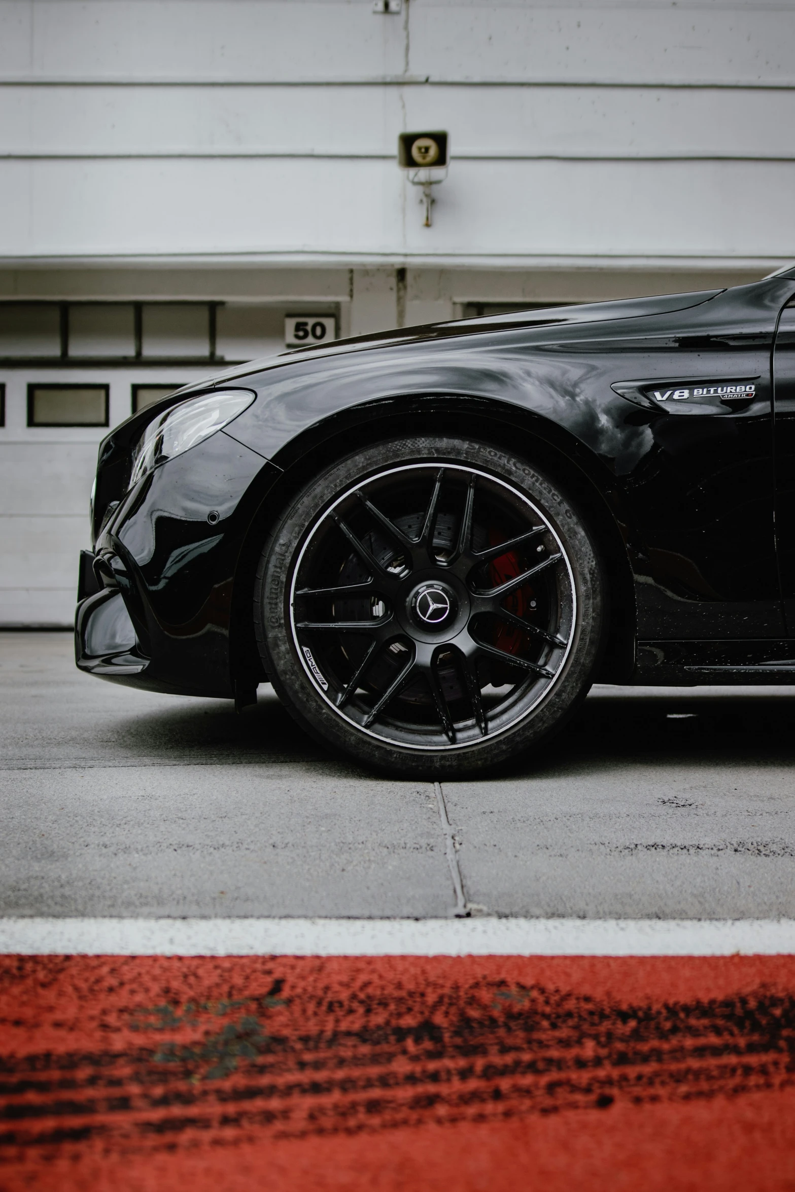 black sports car parked in front of garage