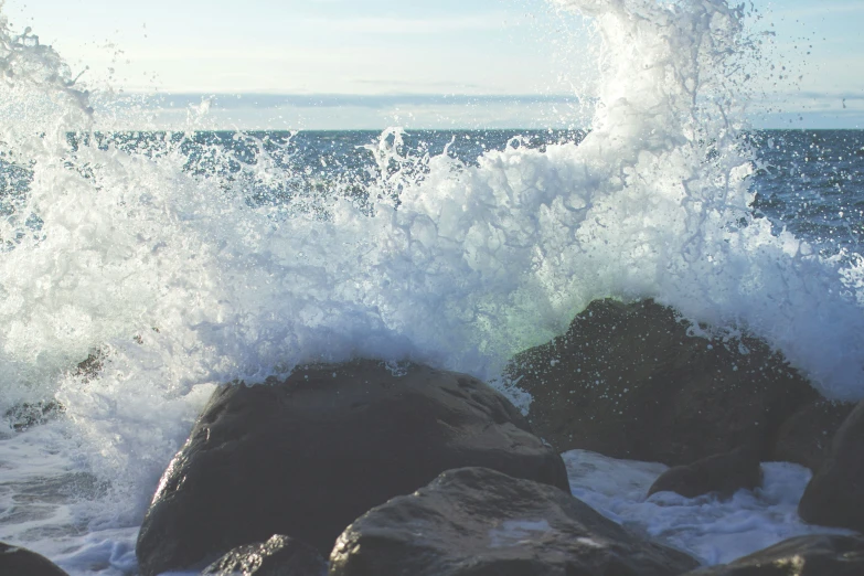 a wave crashing over a bunch of rocks