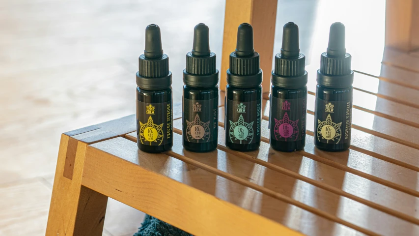 five bottles of essential oil on top of a wooden table