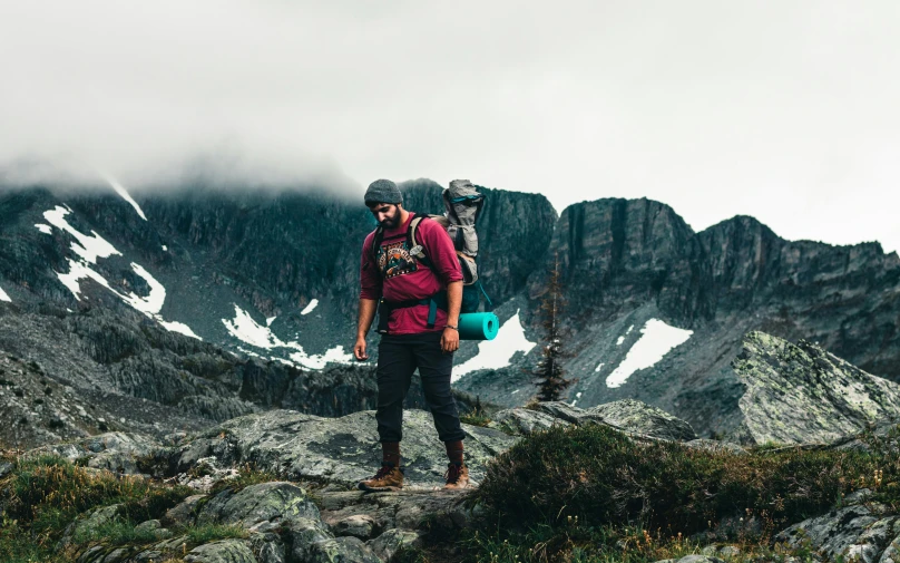 two people wearing helmets on a mountain side