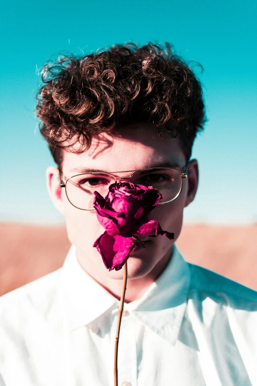 a man with glasses, tie, and flower in his nose