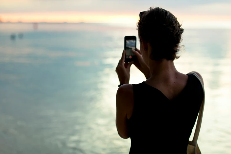 a person taking a po with their phone on the beach