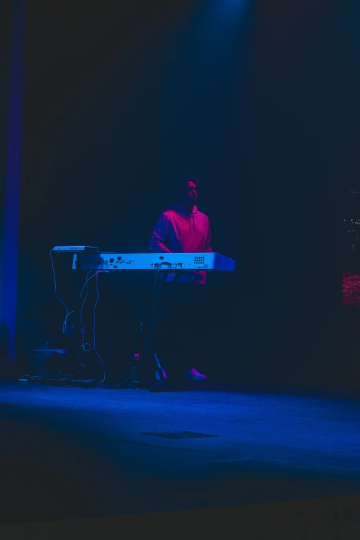 a man playing a keyboard in a dark room