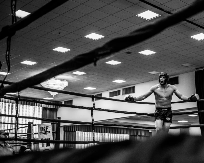 a man standing in a boxing ring with two boxing gloves