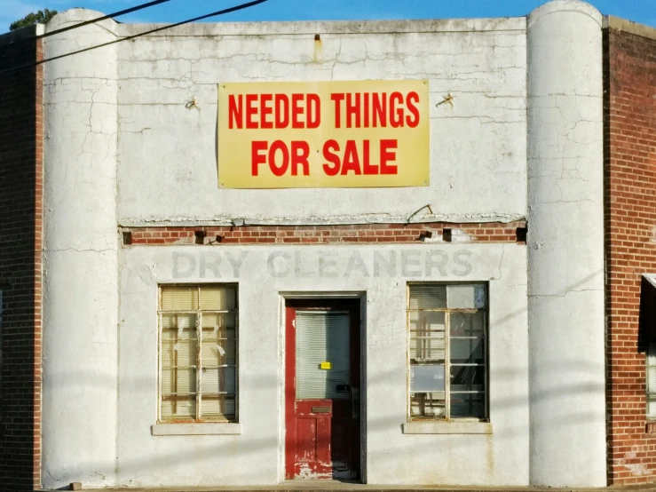 an old building has a sign saying need things for sale