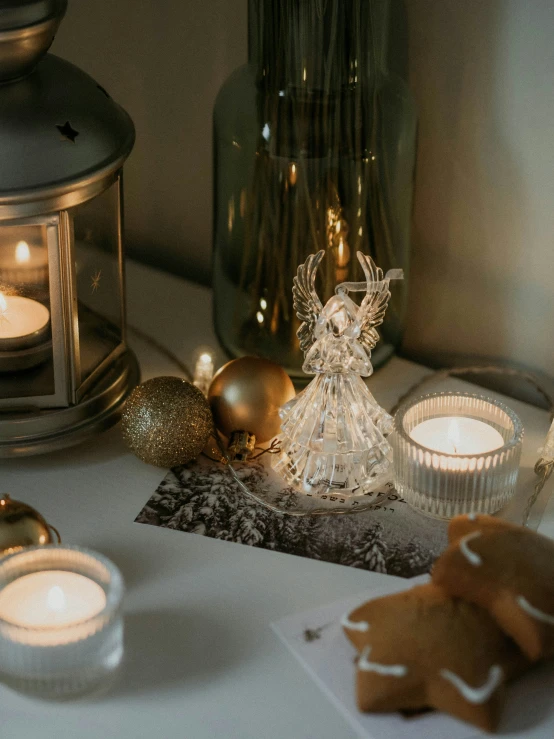 some lit candles some cookies and an angel