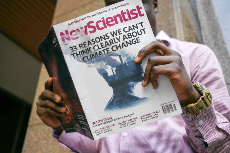 a man holding up a magazine in his hands